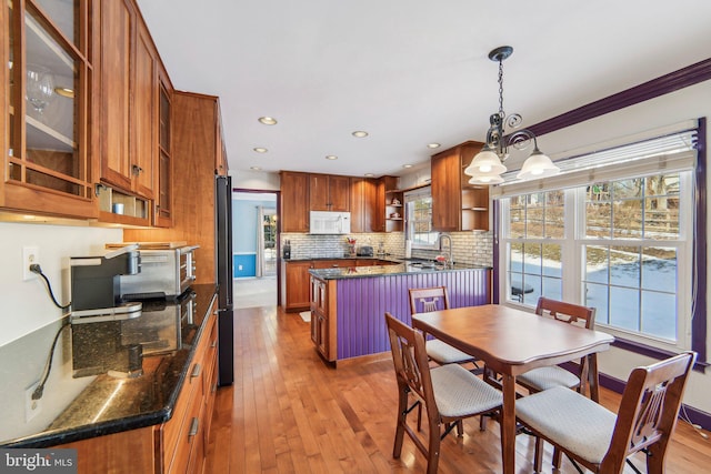 dining space featuring crown molding, plenty of natural light, a notable chandelier, and light hardwood / wood-style floors