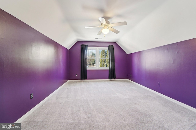 additional living space with lofted ceiling, light carpet, and ceiling fan