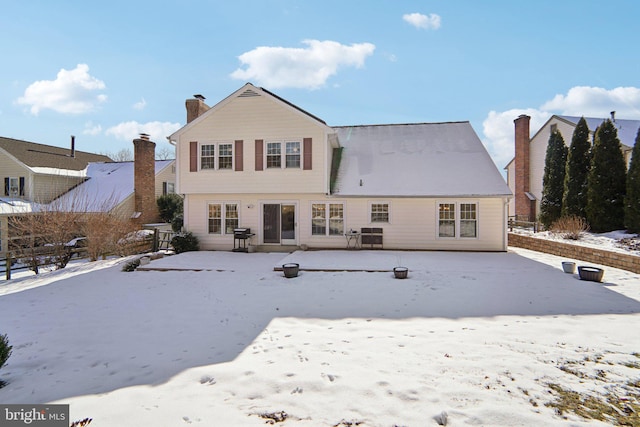 view of snow covered back of property