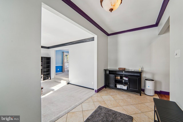 carpeted foyer featuring ornamental molding