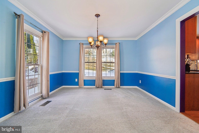 carpeted spare room with an inviting chandelier and crown molding