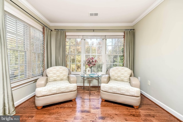 living area with hardwood / wood-style floors, crown molding, and plenty of natural light