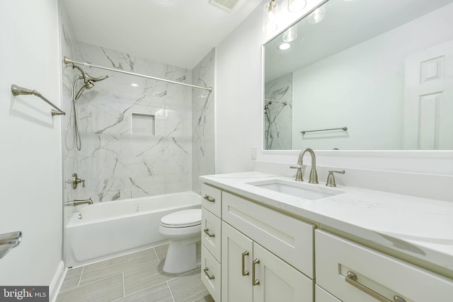 full bathroom with tiled shower / bath, vanity, and toilet