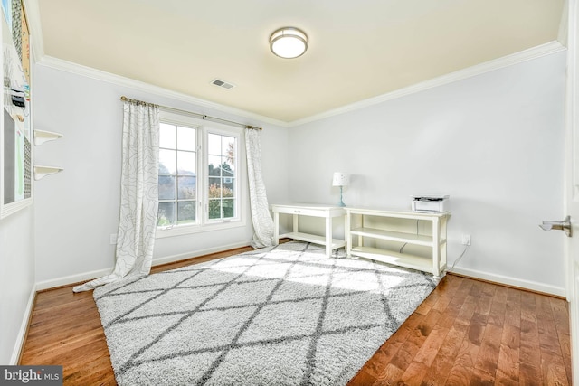 interior space with ornamental molding and wood-type flooring