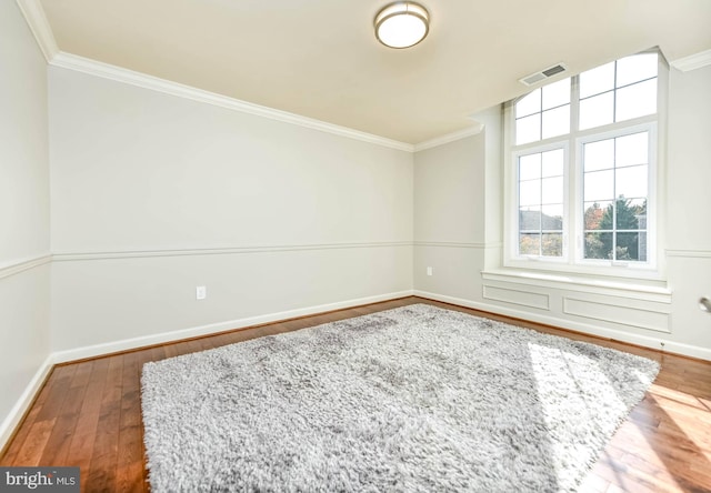 empty room with crown molding and hardwood / wood-style flooring