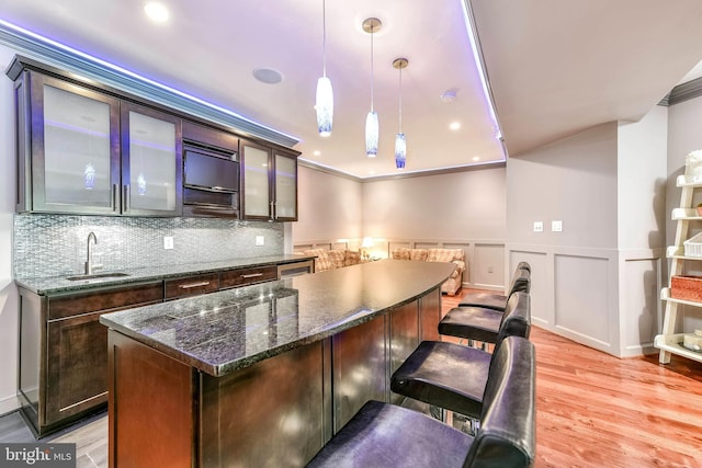 kitchen with a kitchen island, dark brown cabinets, sink, and pendant lighting