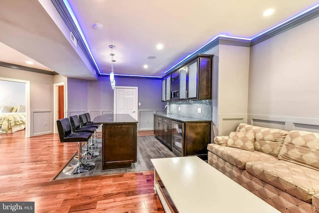 interior space with wine cooler, dark hardwood / wood-style floors, sink, and crown molding