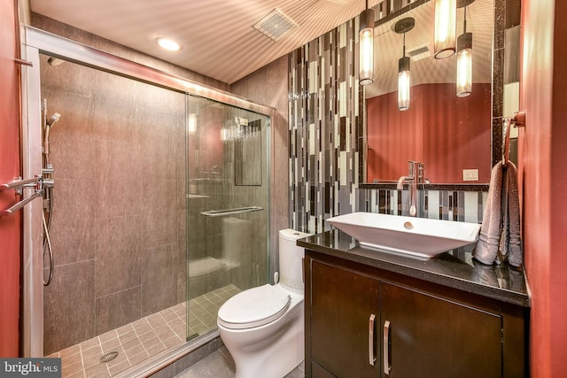 bathroom featuring a shower with door, vanity, and toilet