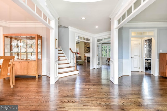 entryway with crown molding and dark wood-type flooring