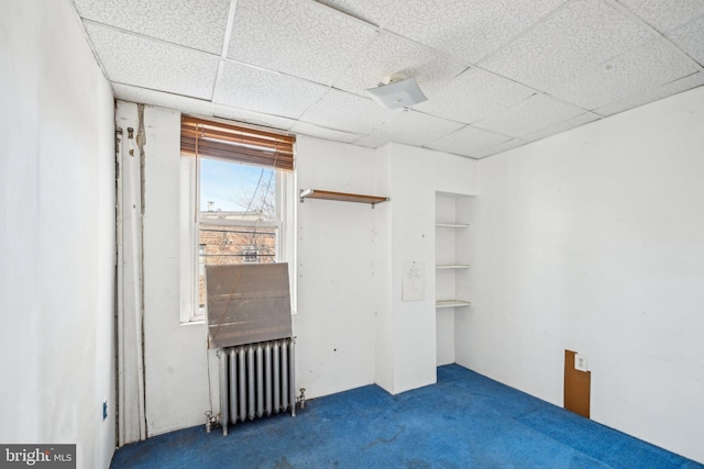 empty room with radiator and dark carpet