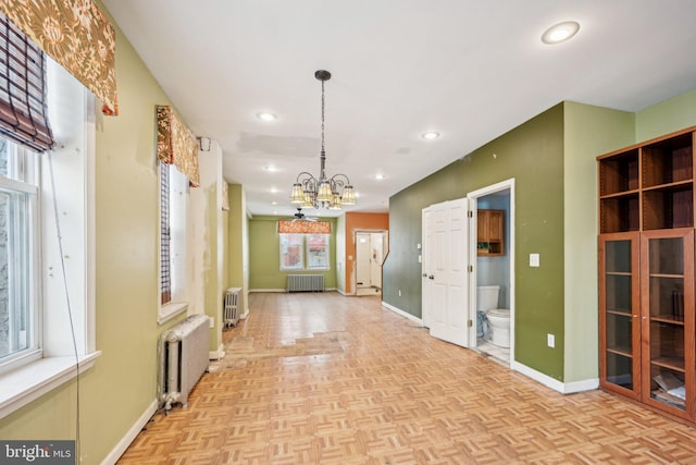 interior space with light parquet flooring, radiator heating unit, and a chandelier