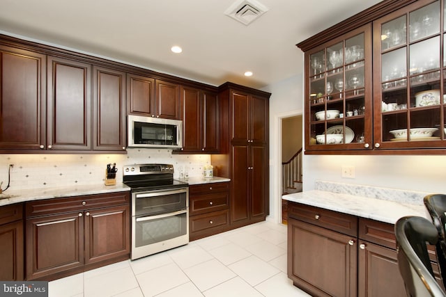 kitchen featuring tasteful backsplash, stainless steel appliances, and dark brown cabinets