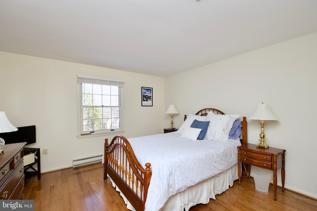 bedroom featuring hardwood / wood-style flooring and a baseboard radiator