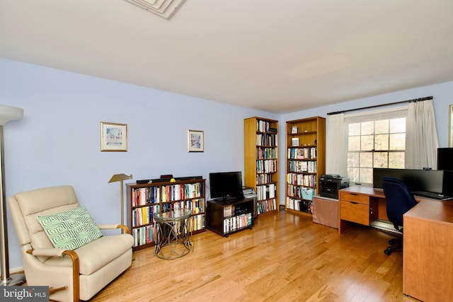 home office with light hardwood / wood-style floors