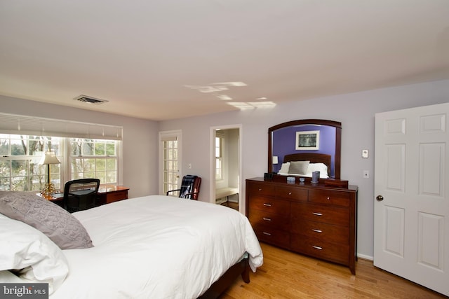 bedroom featuring light hardwood / wood-style floors and ensuite bathroom