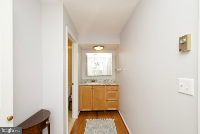 hallway featuring sink and light hardwood / wood-style floors