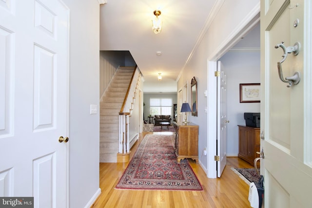 corridor featuring ornamental molding and light hardwood / wood-style flooring