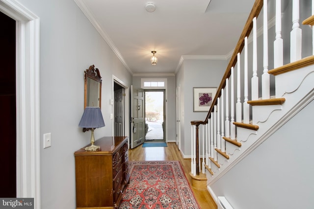 entryway featuring a baseboard heating unit, crown molding, and light hardwood / wood-style flooring