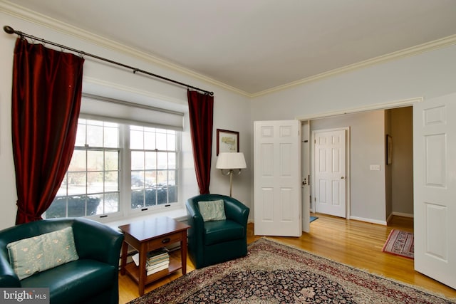 sitting room with hardwood / wood-style flooring and crown molding