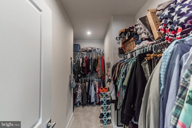 walk in closet featuring light colored carpet