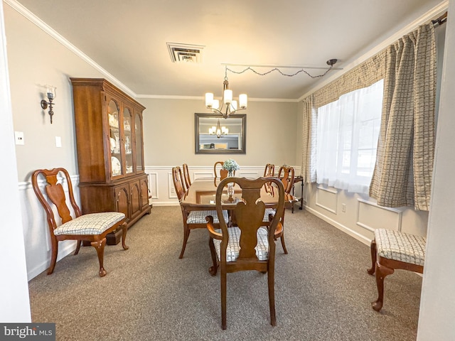 dining area featuring dark carpet, ornamental molding, and an inviting chandelier