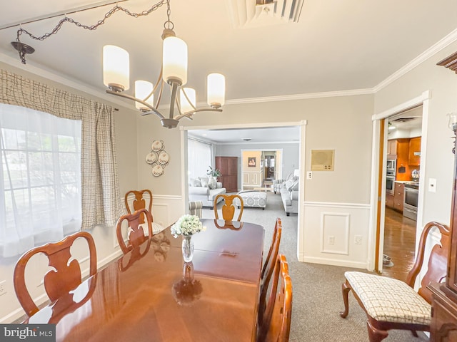 dining area featuring a chandelier, carpet flooring, and ornamental molding