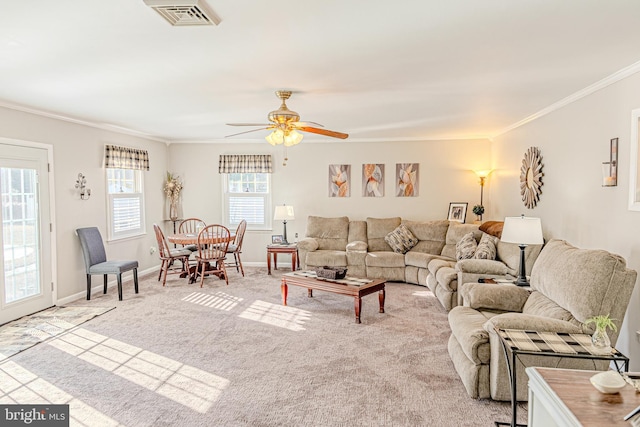 carpeted living room featuring ceiling fan, a wealth of natural light, and ornamental molding