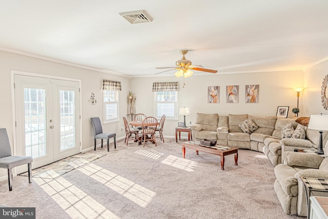 carpeted living room featuring ceiling fan, french doors, a healthy amount of sunlight, and ornamental molding