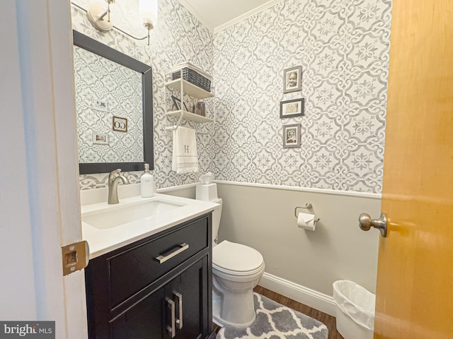 bathroom featuring hardwood / wood-style flooring, toilet, vanity, and crown molding