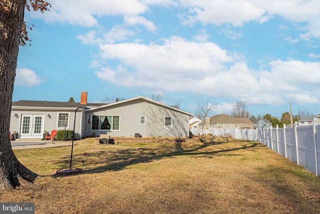 rear view of house with a lawn and a patio