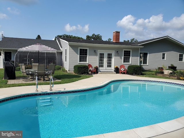 view of pool with french doors and a patio area