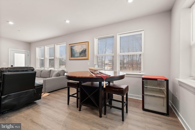 dining room featuring wine cooler, plenty of natural light, and light hardwood / wood-style floors