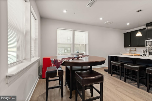 dining area with sink and light hardwood / wood-style floors