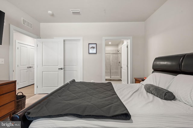 bedroom featuring connected bathroom and light hardwood / wood-style floors