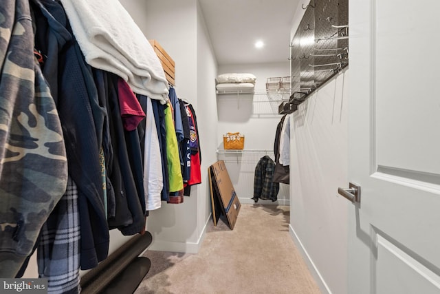 walk in closet featuring light carpet