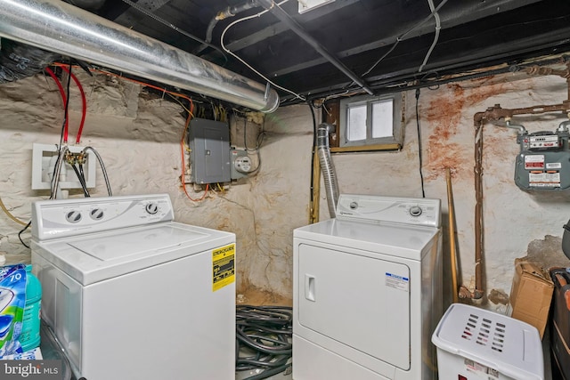 clothes washing area with washing machine and dryer and electric panel