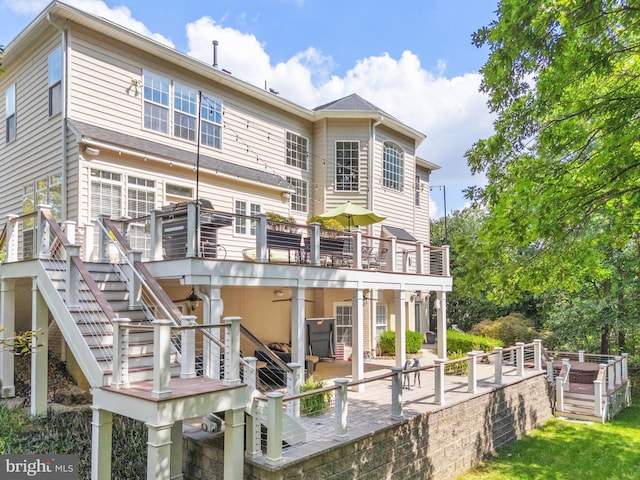 back of property with a wooden deck and a patio area