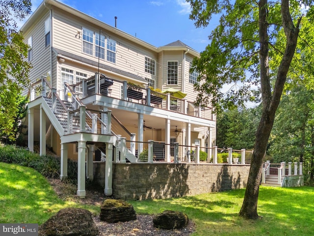 rear view of property featuring a wooden deck, ceiling fan, and a lawn