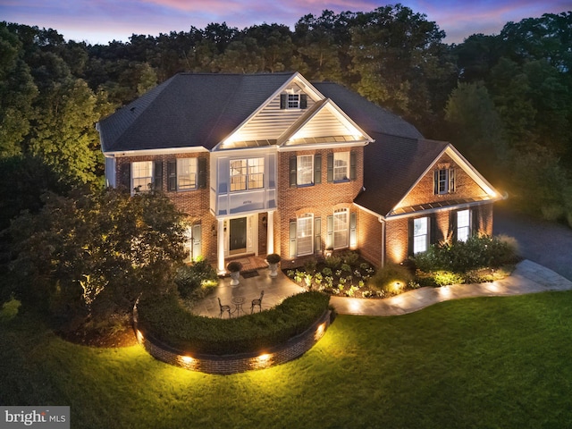 view of front facade with a patio and a lawn