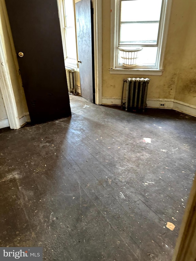 empty room featuring dark hardwood / wood-style flooring and radiator