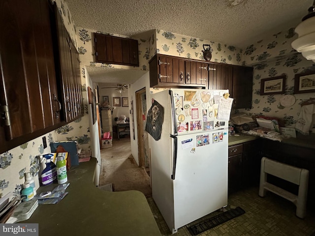 kitchen featuring a textured ceiling, dark brown cabinetry, ceiling fan, and white fridge