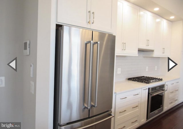 kitchen featuring backsplash, appliances with stainless steel finishes, and white cabinets