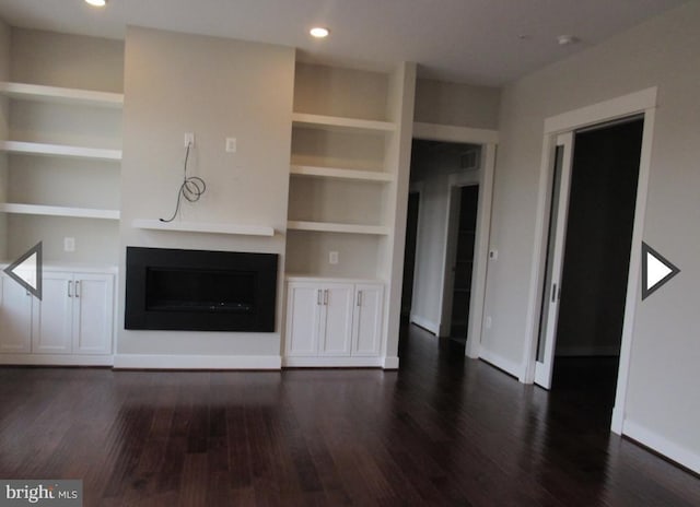 unfurnished living room with built in features and dark hardwood / wood-style floors