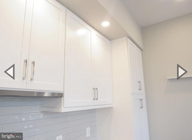 room details featuring tasteful backsplash and white cabinetry