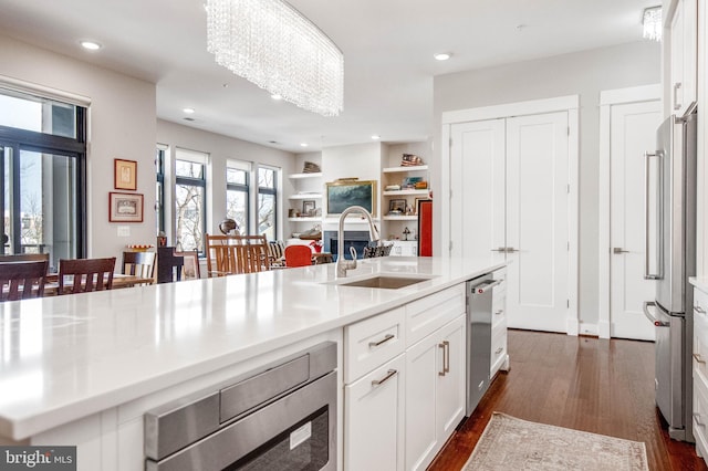 2 Stationmaster St SE Unit 302, Leesburg, VA 20175 - kitchen with white cabinets, appliances with stainless steel finishes, a sink, light countertops, and dark wood-type flooring