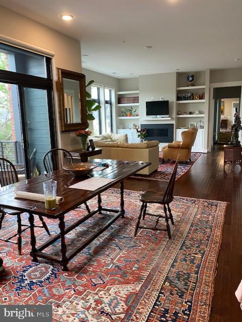 living room featuring hardwood / wood-style floors and built in shelves