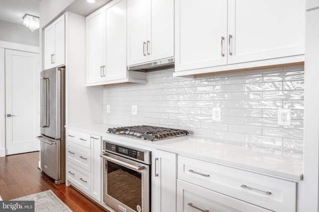 2 Stationmaster St SE Unit 302, Leesburg, VA 20175 - kitchen featuring backsplash, dark wood finished floors, light countertops, white cabinets, and stainless steel appliances