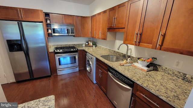 kitchen featuring dark hardwood / wood-style floors, washer / clothes dryer, sink, stainless steel appliances, and light stone counters