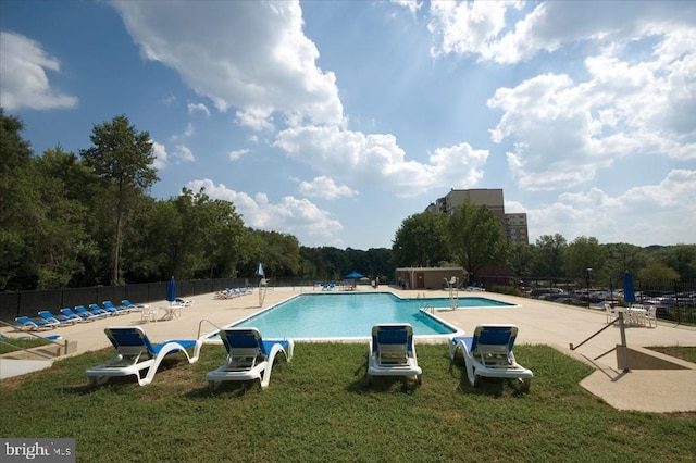 view of pool with a patio area and a yard