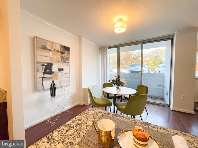 dining room with dark hardwood / wood-style flooring and crown molding